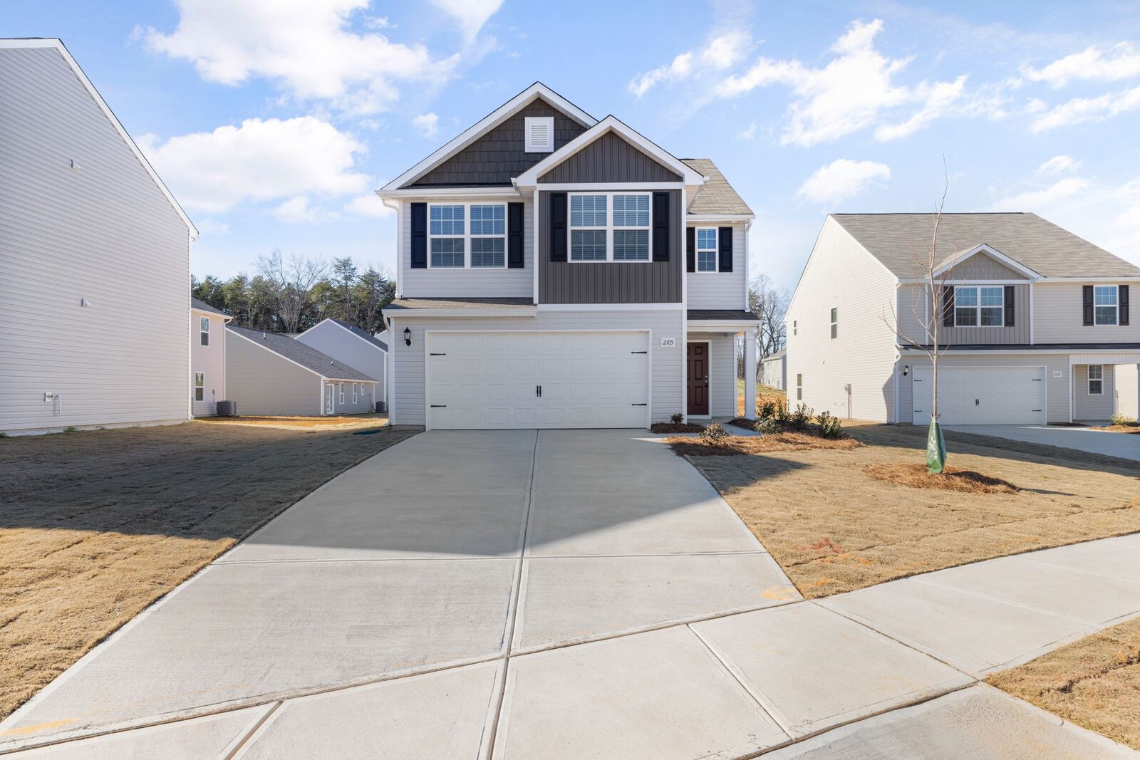 Concrete driveway leading from the street to a new two-storey house